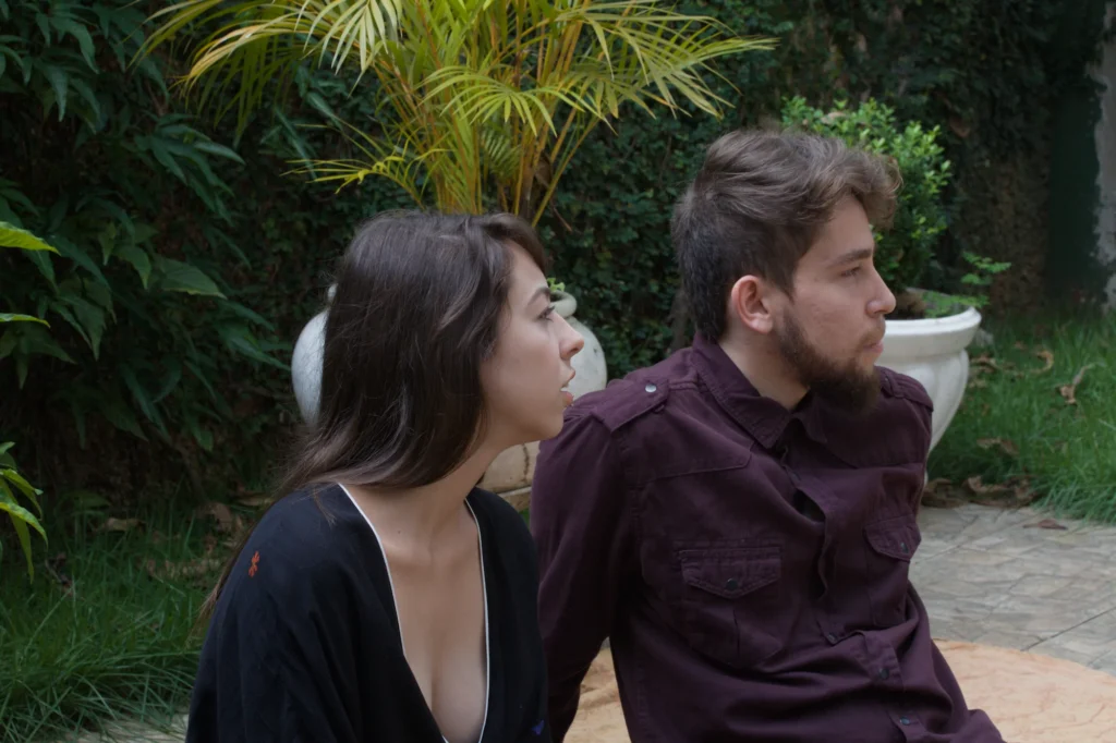 Casal sentado lado a lado num jardim