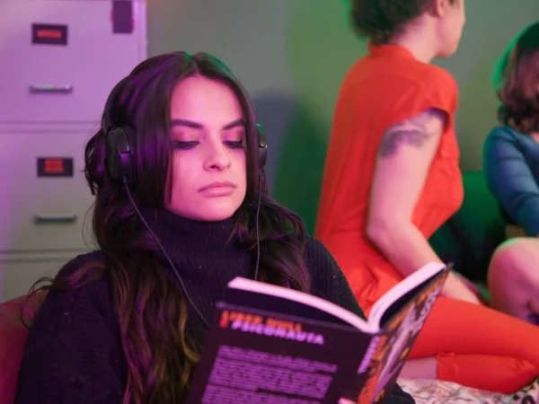 Mulher de fones de ouvido lendo um livro