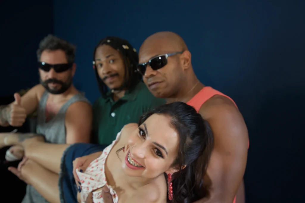 Três homens de óculos escuros e uma mulher sorrindo